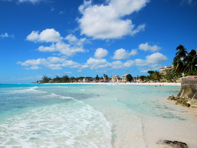 beach with turquoise, clear water and beachfront villas in distance