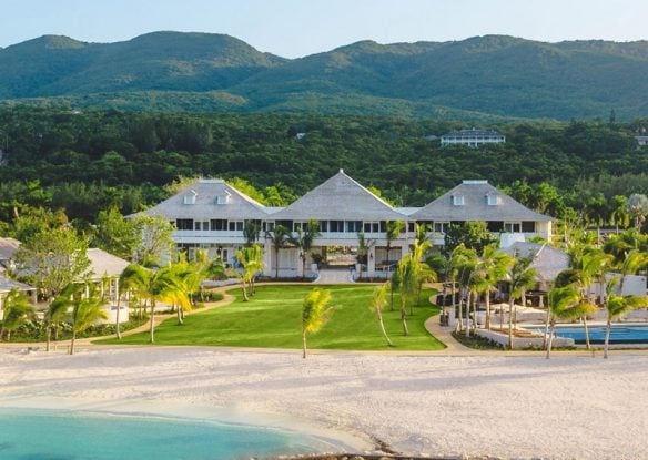 three roofed hotel with lawn and beach