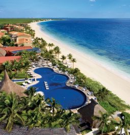 aerial view of hotel pool next to beach and blue ocean