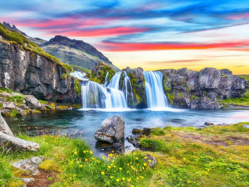 Fantastic view on Kirkjufellsfoss waterfall near Kirkjufell mountain at sunset.