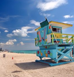 turquoise and yellow lifeguard stand overlooking beach