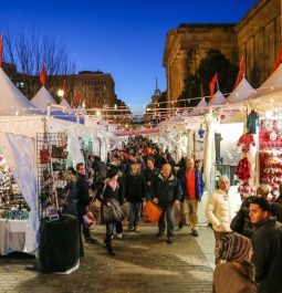 Busy Christmas market with crowds of people and tents of vendors