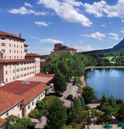 The Broadmoor Resort overlooks a lake with mountains in the background