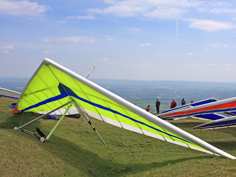 Hang gliders on a hill prepared to fly