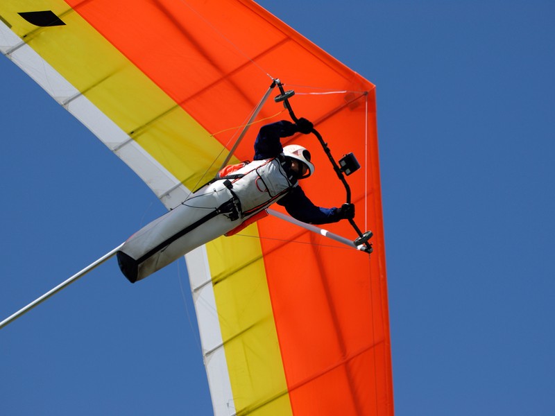 Yellow-red hang-glider under control in the sky