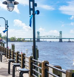 Waterfront riverwalk with suspension bridge in distance