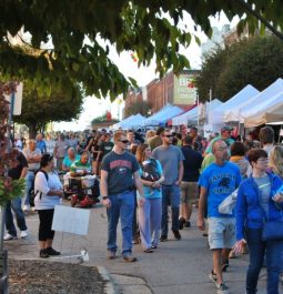 Crowd of festival goers walking alongside arts and crafts stands