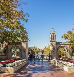 Family walks with college student out main gates of campus down into the town