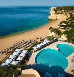 pool and beach with lounge chairs lined up