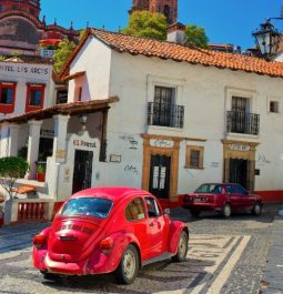 steep colonial street with red buggy