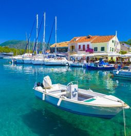 crystal-clear turquoise water with boats docked at small marina