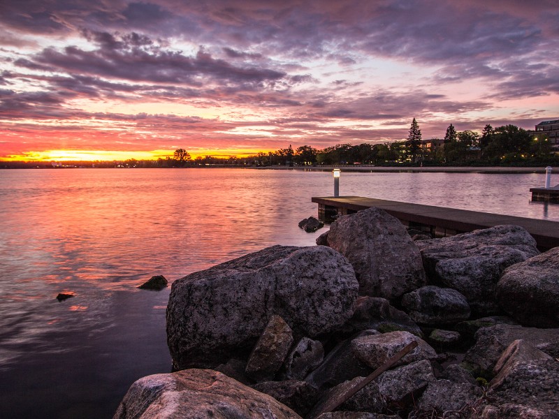 Morning sunrise over the rocky coast of Grand Traverse Bay with downtown Traverse City, Michigan in the background