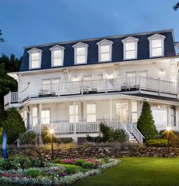 inn with lights on at night and landscaping in the yard