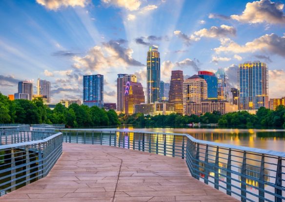 city skyline with lake and boardwalk in foreground