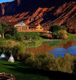 lodge against red cliffs and near a pond