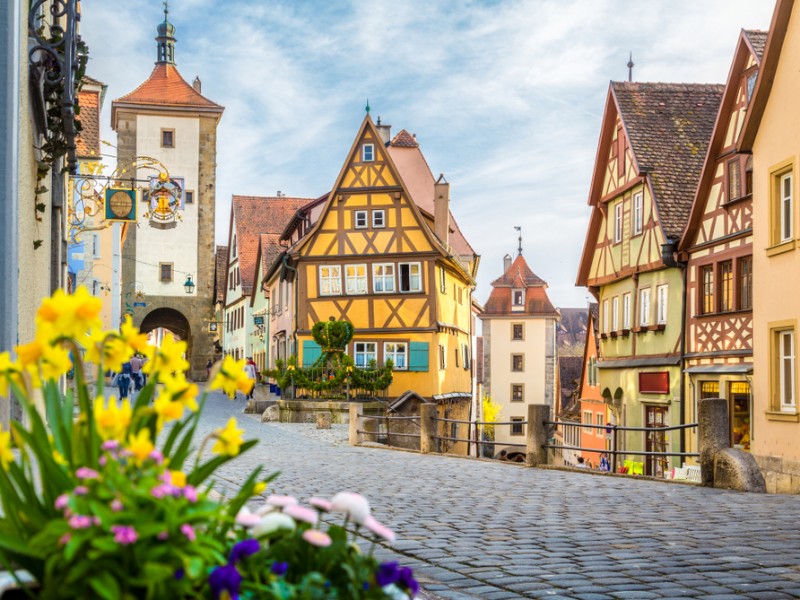 Classic view of the medieval town of Rothenburg ob der Tauber with blooming flowers on a beautiful sunny day 