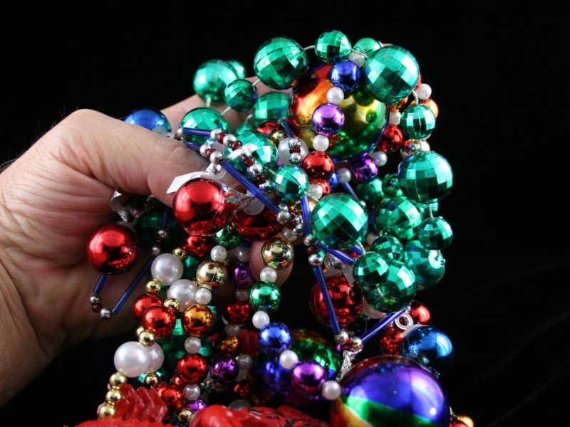 Hand holding Mardi Gras beads