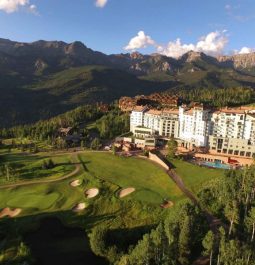 hotel lit up by sun surrounded by mountains