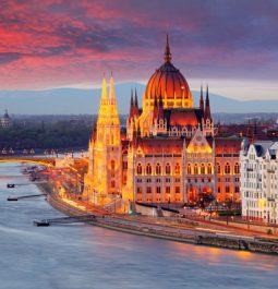 parliament lit up on the right at night in budapest