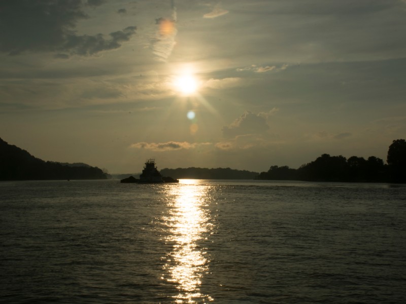 The sun begins to set on the Ohio river at Parkersburg West Virginia with Blennerhassett Island in the distance