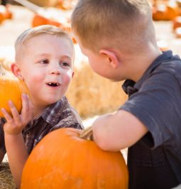 kids holding pumpkins at pumpkin patch