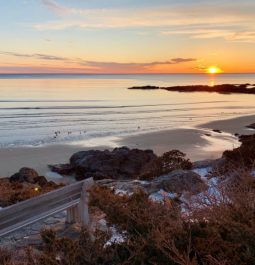 view of sunrise over water and rocky coastline in ogunquit