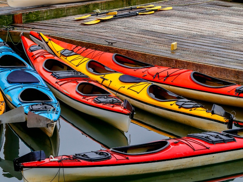 Colorful kayaks standing on the pier with calm waters on Ketchikan