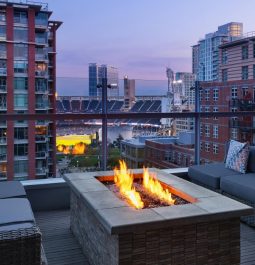 terrace with seating around a fire overlooking a baseball stadium