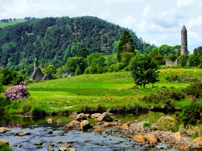 View of the historic Glendalough monastic site with ancient round tower and church in Wicklow National Park