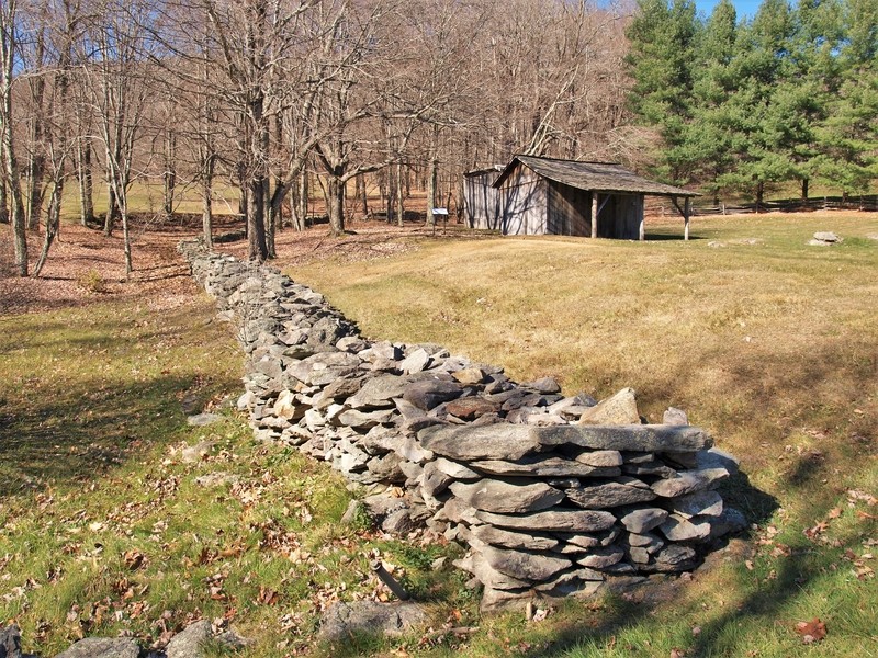 A rock wall surrounds the log cabins that were part of a homestead in Grayson Highlands State Park