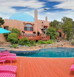 hot tub and pool oasis with pink lawn chairs