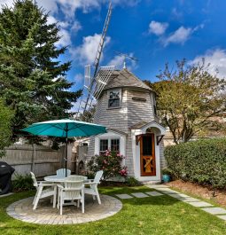 Quaint windmill turned house with table and chairs in front in the yard