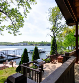 deck overlooking a lawn and lake