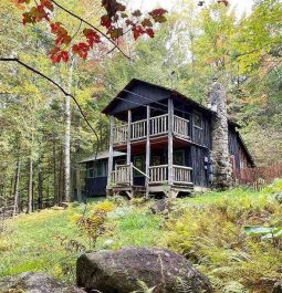 2-story cabin in the woods with fall foliage