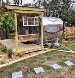 Camper set up next to patio with porch swing