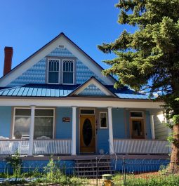 exterior of blue house with greneery