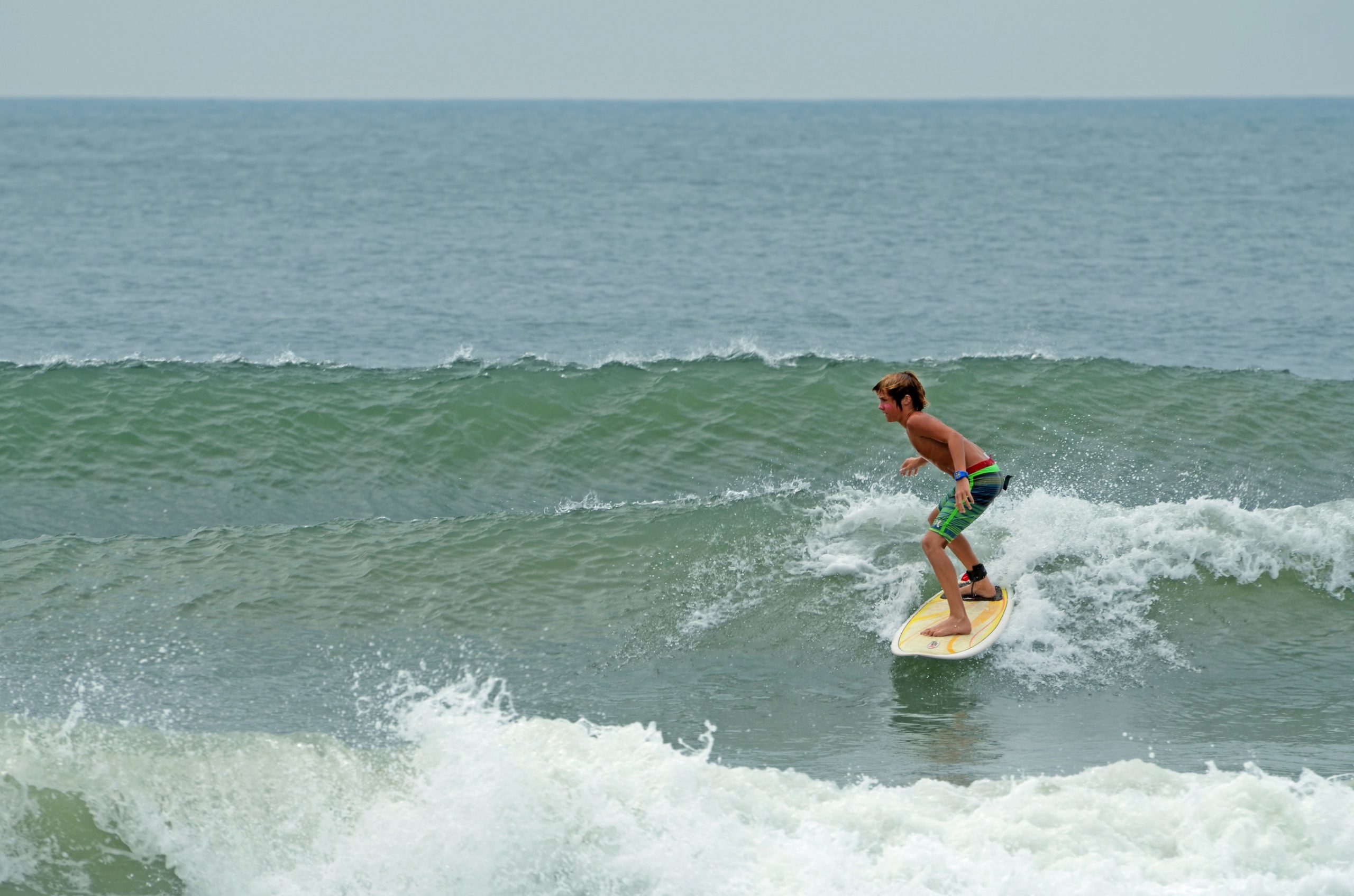 Young boy surfing at Wrightsville Beach