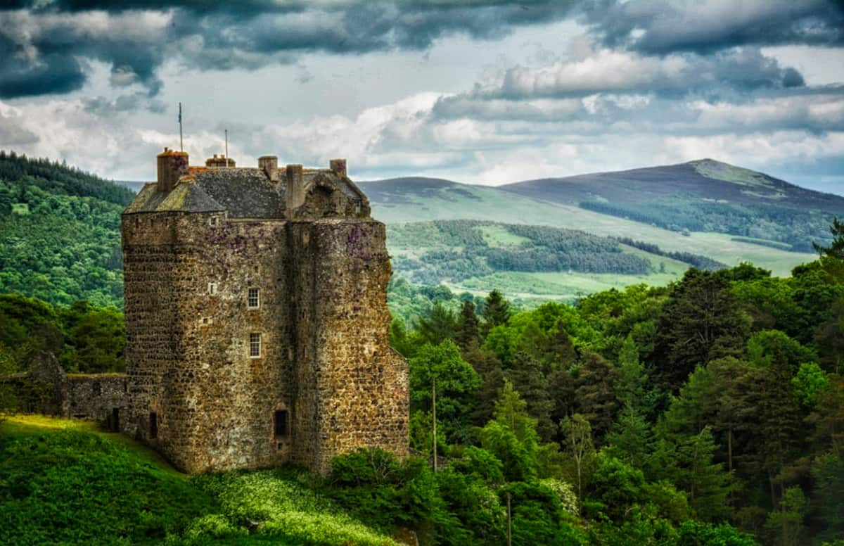 Ancient crumbling castle building set among rolling hills