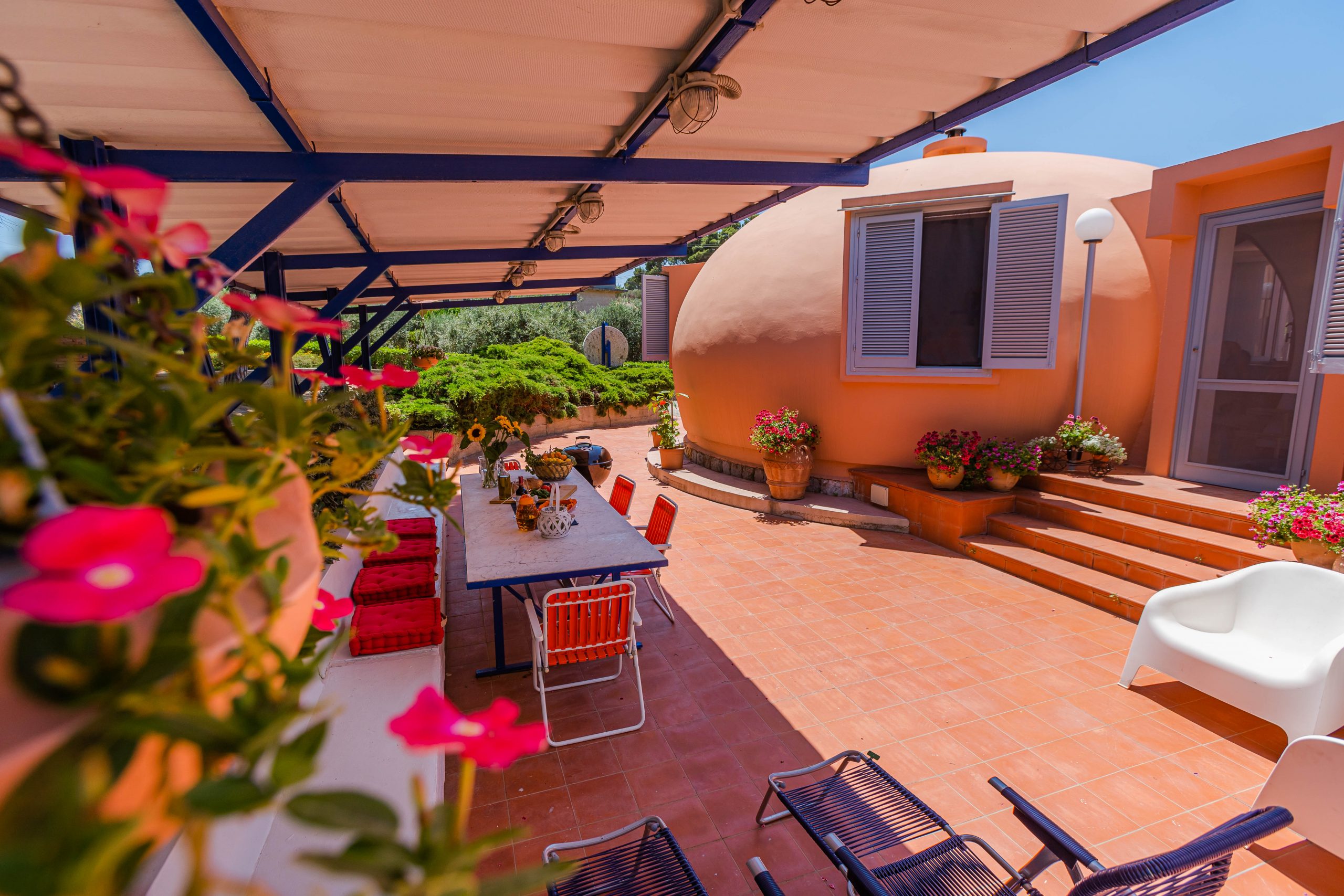 Peach-colored dome house with vibrant flowers