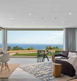 Open living room with sectional sofa and dining set with panoramic views of ocean