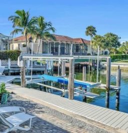 Dock, seating, home exterior, and palm trees