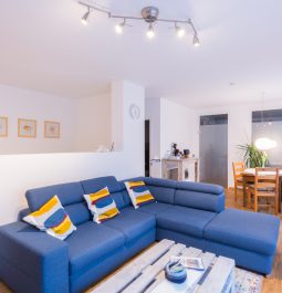 Living room with a big sofa and a dining area in the background