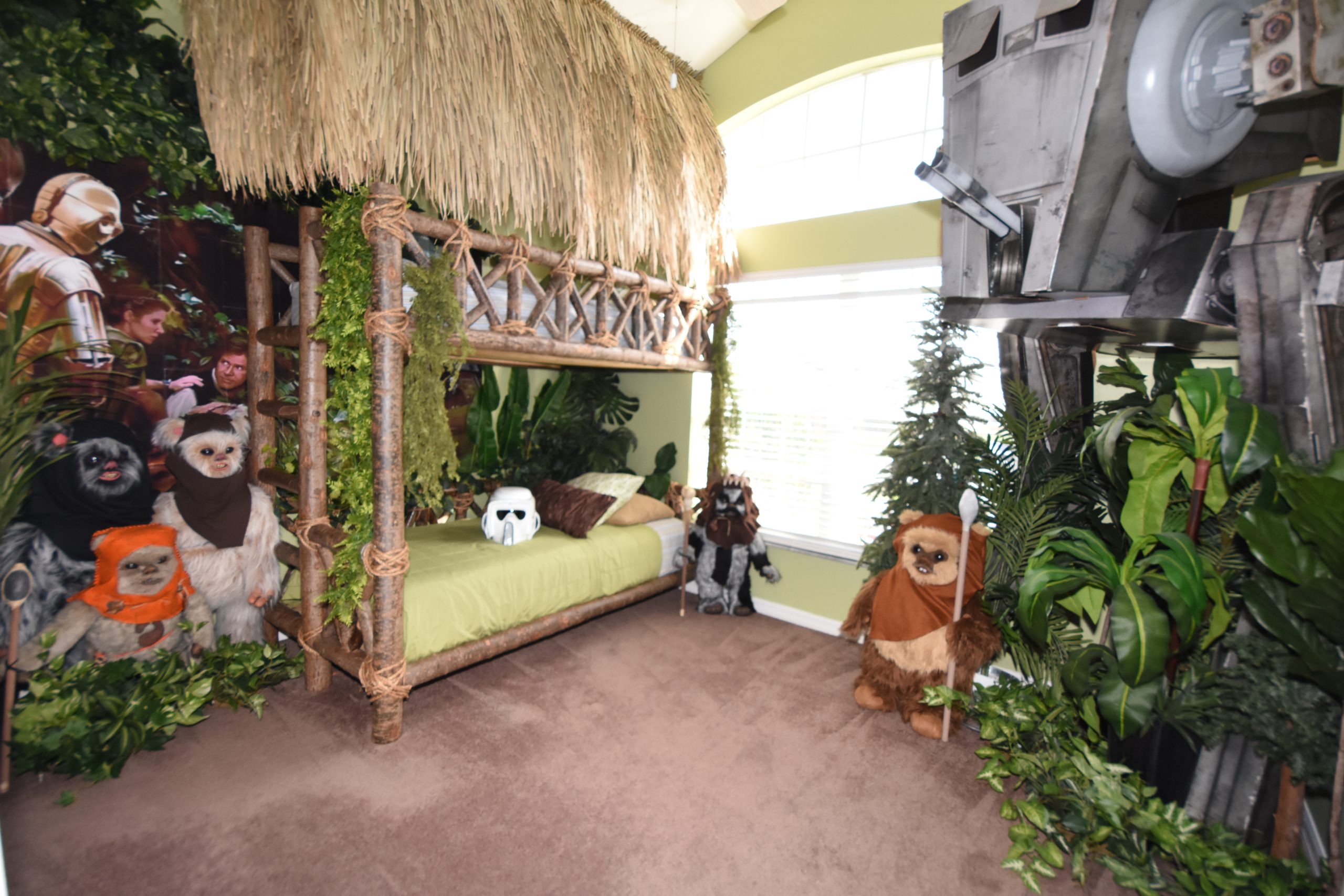 Jungle themed bedroom with straw-thatched bunkbeds, stuffed animals and greenery all around