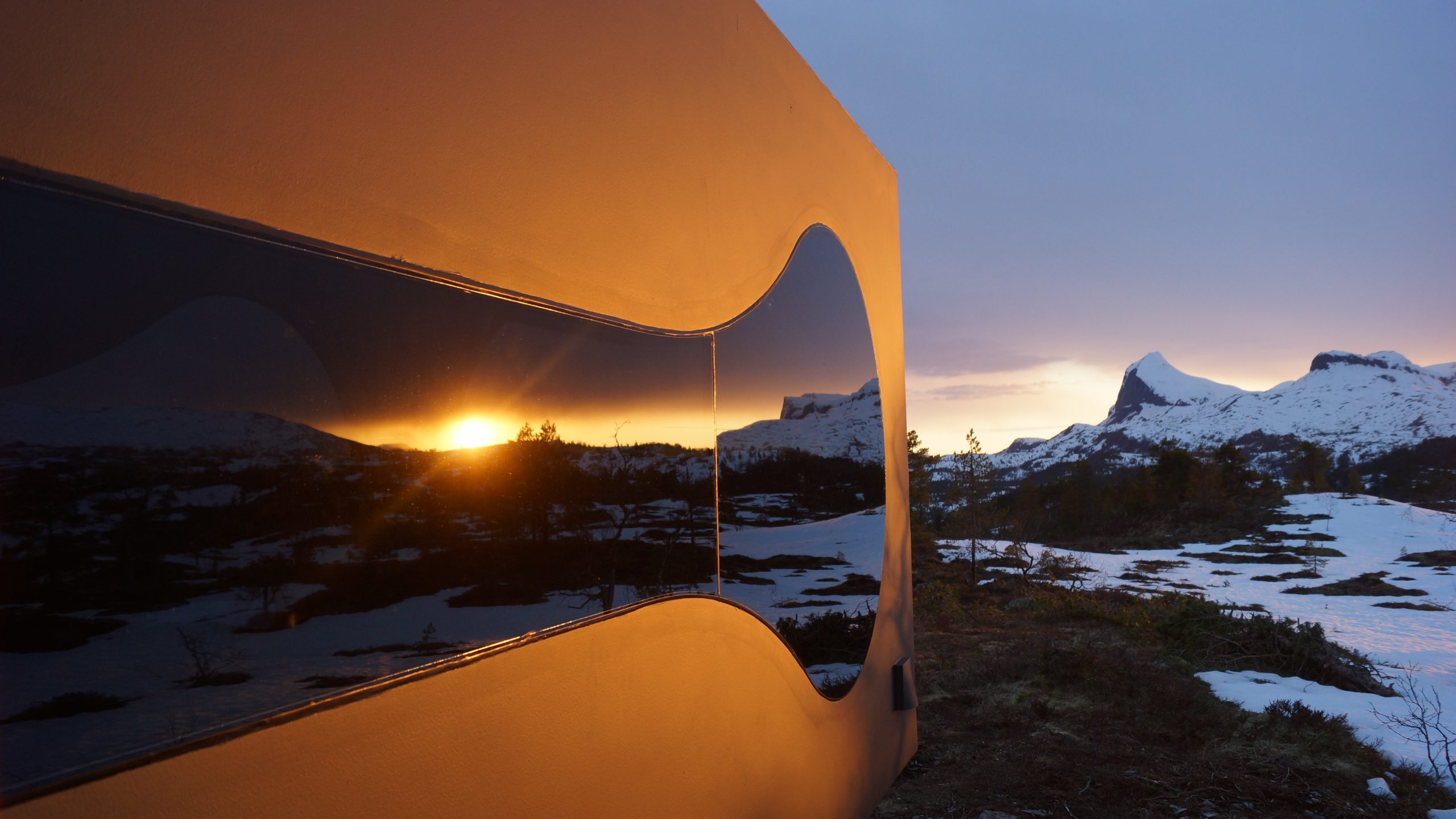 Futuristic looking orange rectangle reflecting snow all around