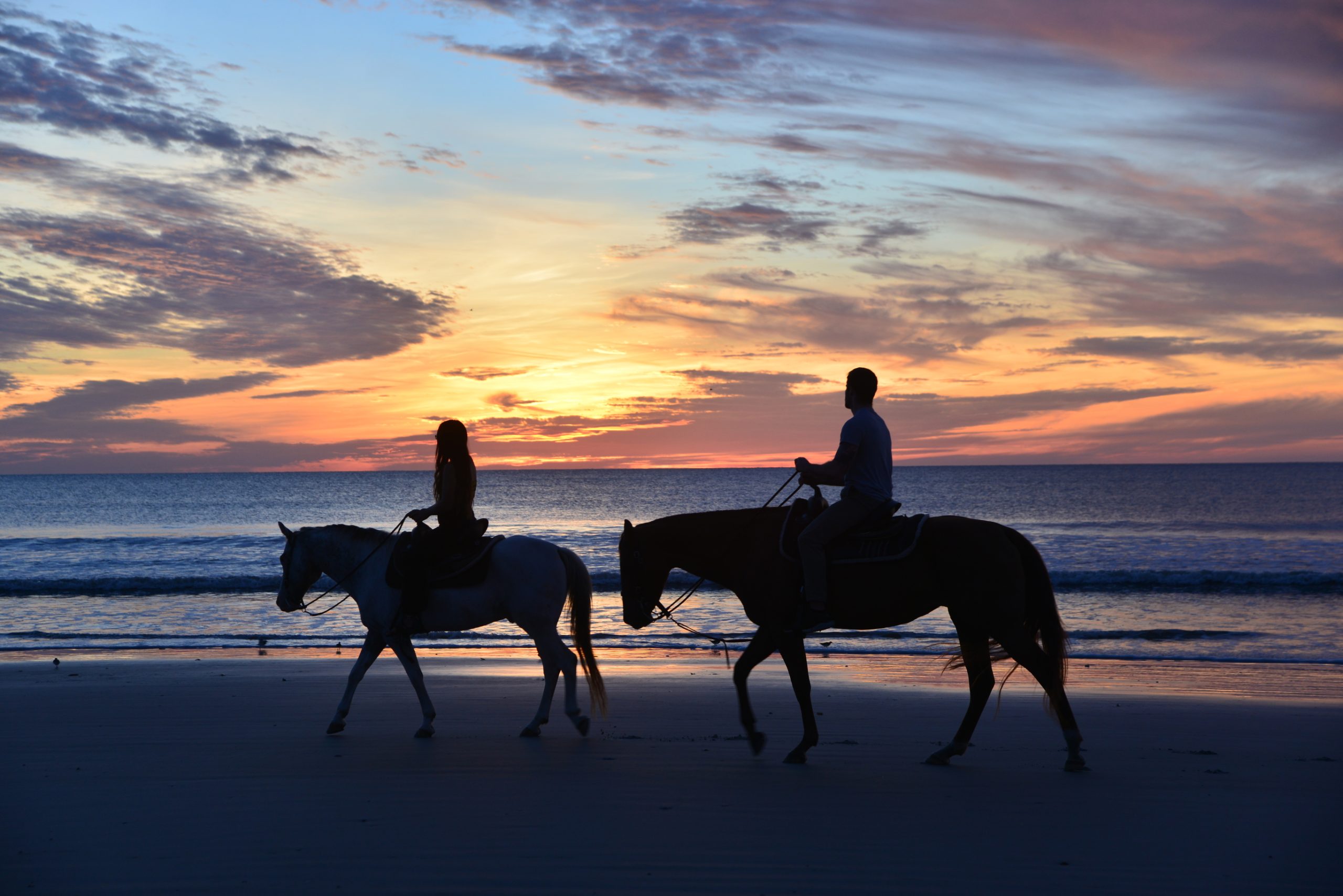 couple riding horses at sunrise, Amelia Island, Florida