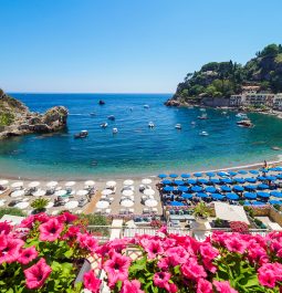 The view of the beach with colored umbrellas and blue sea