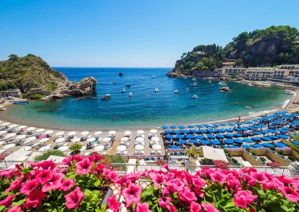 The view of the beach with colored umbrellas and blue sea