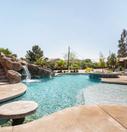 Large, uniquely shaped pool under a blue sky