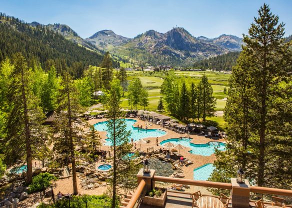 view of pools through trees with mountains in background