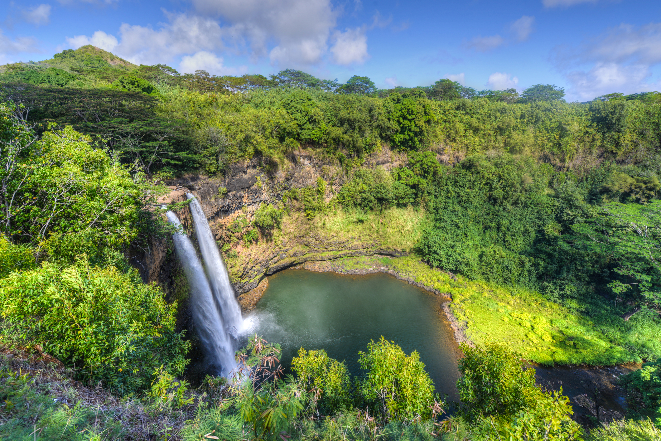 The Wailua Waterfall on the island of Kauai flows into the Wailua River